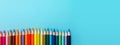 Colored pencils on a blue background, top view with copy space Royalty Free Stock Photo