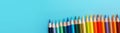 Colored pencils on a blue background, top view with copy space Royalty Free Stock Photo