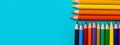 Colored pencils on a blue background, top view with copy space Royalty Free Stock Photo