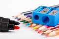 Colored pencils and blue pencil sharpener on white background Royalty Free Stock Photo