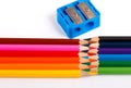 Colored pencils and blue pencil sharpener on white background Royalty Free Stock Photo