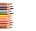 Colored pencils border isolated on a white background. Colorful crayons frame. Copy space, top view