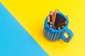 Colored pencils in a bucket on blue and yellow background. Back to scool concept Royalty Free Stock Photo