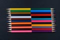 A set of colored pencils sharpened on both sides on a black chalk board Royalty Free Stock Photo