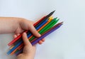 Colored pencils in children`s hands. Top view, training concept.copyspace for text