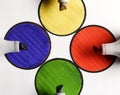 Colored pencils on colored papers arranged as a crossroads with circles Royalty Free Stock Photo