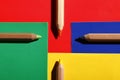 Colored pencils on colored papers arranged as a crossroads Royalty Free Stock Photo
