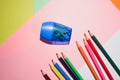 The colored pencils on a colorful background with pencil sharpener Royalty Free Stock Photo