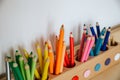 Colored pencils in a container on a wooden table, close up on yellows