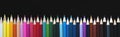 Colored pencils on a dark background. Panorama. Royalty Free Stock Photo