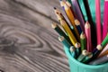 Colored pencils for drawing.  They stand in a pencil holder in the form of a trash can. On pine boards.  Close-up Royalty Free Stock Photo