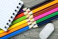 colored pencils, eraser, notebook closeup on wooden table Royalty Free Stock Photo