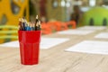 Colored pencils in a glass on a table. Royalty Free Stock Photo