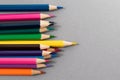 Colored pencils on gray paper with space to write to the right. Crowd concept. Focus on yellow pencil in foreground Royalty Free Stock Photo
