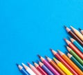 Colored pencils isolated on blue background close up concept with copy space for text Royalty Free Stock Photo