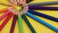 Colored Pencils Lying on Bright Yellow Background in a Circle.