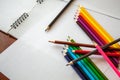 Colored pencils are lying on white sheets of paper Royalty Free Stock Photo