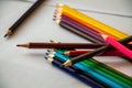 Colored pencils are lying on white sheets of paper Royalty Free Stock Photo