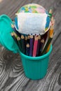 Colored pencils in a pencil holder. Nearby is a globe with a medical mask. Academic year during the epidemic