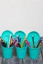 Colored pencils in pencil holders. A pencil case in the form of a trash can. On brushed pine boards painted black and white Royalty Free Stock Photo