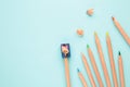 Colored pencils and pencil sharpener on the blue pastel background Royalty Free Stock Photo