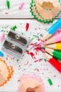 Colored pencils and pencil sharpener on a white wooden background Royalty Free Stock Photo