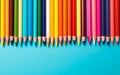 Colored pencils in a row on blue background with copy space, top view, flat lay, teacher\'s day promotion banner Royalty Free Stock Photo