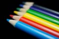 Colored pencils in a row isolated on a black background Royalty Free Stock Photo