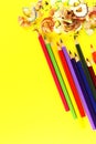 Colored pencils with shavings on a yellow background Royalty Free Stock Photo