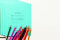 Colored pencils and school notebooks lie on a white wooden table Royalty Free Stock Photo