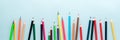 Colored pencils, scissors, notebook, ruler, pen, eraser, sharpener and more in glass. School and office stationery on light blue b Royalty Free Stock Photo