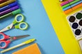 Colored pencils, scissors. School office on a yellow blue background. copy space