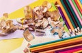 Colored pencils and sharpener with shavings on a yellow background. Preparing pencils for drawing Royalty Free Stock Photo