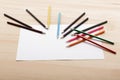 colored pencils and sheet of white paper on desk Royalty Free Stock Photo