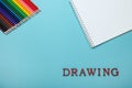 Colored pencils and a sketch pad on a blue background Royalty Free Stock Photo