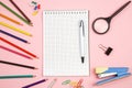 Colored pencils, stationery, paper notebook with pen and magnifier on pink isolated background. top view. flat lay. mockup Royalty Free Stock Photo