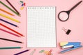 Colored pencils, stationery, paper notebook with pen and magnifier on pink isolated background. top view. flat lay. mockup Royalty Free Stock Photo