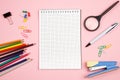 Colored pencils, stationery, paper notebook with pen and magnifier on pink isolated background. top view. flat lay. mockup Royalty Free Stock Photo