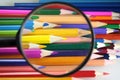 Colored pencils under loop - careful choice of color Royalty Free Stock Photo