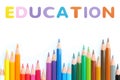 Colored pencils wave with alphabet sponge rubber of text `EDUCATION` over white background Royalty Free Stock Photo