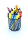 Colored pens and highlighters in holder on white tabletop
