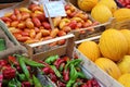 Colored peppers, yellow melons, red long cirio tomatoes, vegetable products laid out on the market, vegetables stacked in wooden c