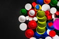 Colored PET caps on a black background with copy space. Recycled plastic bottle caps. Separate garbage collection. Recycling of Royalty Free Stock Photo