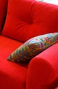 Colored pillow with pattern on red sofa. Rest, sleeping, comfort concept