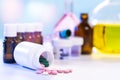 Colored pills spill out of a plastic medicine bottle onto a white table. Many vials of drugs. Pharmaceutical industry. Health care Royalty Free Stock Photo