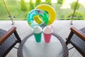 Colored plastic cocktail glasses are on the table on the balcony, on background inflatable mattress. Vacation concept Royalty Free Stock Photo