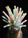 Colored plastic drinking straws on a black table Royalty Free Stock Photo
