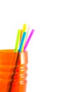 Colored plastic drinking straws in the orange cup on white background. Royalty Free Stock Photo