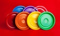 Colored plastic plates on red background Royalty Free Stock Photo