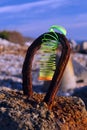 Colored plastic spring on a rusty loop of reinforced concrete shore reinforcement. Royalty Free Stock Photo